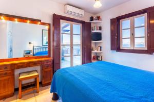 a bedroom with a bed and a desk and a mirror at Villa Ponente in Spetses