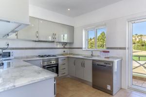 a kitchen with white appliances and a large window at FLH Praia da Luz Apartment with Pool in Alagoas