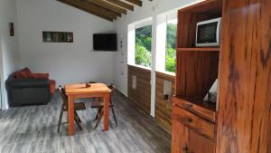 sala de estar con mesa de madera y TV en APPARTEMENT MILO 1 en Bouillante