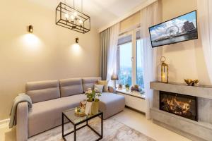 a living room with a couch and a fireplace at Apartament Champagne Gdańsk in Gdańsk