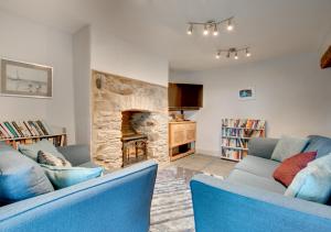 a living room with two blue chairs and a stone fireplace at Tan y Garth in Denbigh