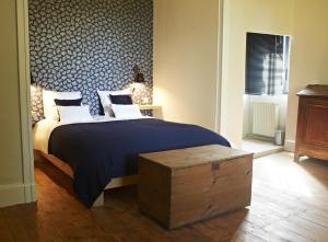 1 dormitorio con 1 cama grande y una pared con estampado azul en Chambres d'hôtes du Domaine de Bonnery en Caucalières