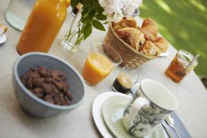 een tafel met een ontbijt van brood en jus d'orange bij Chambres d'hôtes du Domaine de Bonnery in Caucalières