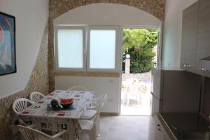 a dining room with a table and a kitchen at Villa Simonetta in Alliste