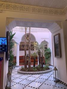 eine Lobby mit einem Brunnen mit Palmen in der Unterkunft Riad Abaka hotel & boutique in Marrakesch