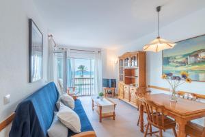 een woonkamer met een blauwe bank en een tafel bij Empurialola -Apartamento en primera linea de ma vistas al mar -164 in Empuriabrava