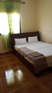 a large bed in a bedroom with a window at Afilux Residencial in Luanda