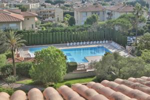 ein Schwimmbad in einem Garten neben einem Zaun in der Unterkunft Pierre et Vacances Résidence Amandine in Saint-Tropez