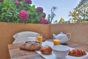 stół z wypiekami i kubkami soku pomarańczowego na nim w obiekcie Pierre et Vacances Résidence Amandine w Saint-Tropez