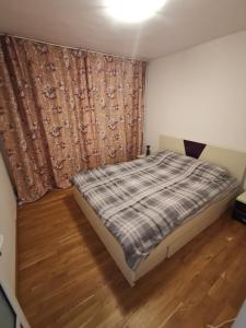 Habitación pequeña con cama y cortina en Confortable Cozy Apt en Bucarest