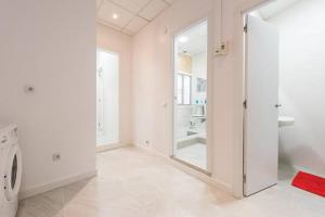 biała łazienka z umywalką i pralką w obiekcie M&F Apartaments Gran Via w Madrycie