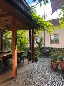 eine Außenterrasse mit Tischen, Stühlen und Bäumen in der Unterkunft Family Lorenz & Coffee House in Prag
