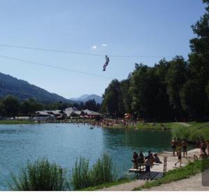 een groep mensen die rond een meer met een vlieger staan bij CHALET Indépendant Les Petits Yetis in Verchaix