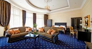 a hotel room with a couch and a bed at Villa Le Premier in Odesa
