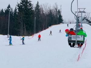 a group of people on a ski lift in the snow at Hotel Superski in Cavnic