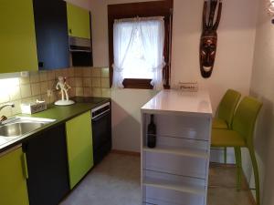 una cucina con armadi verdi e bianchi e un lavandino di Hotel Platten Apartment a Gersau
