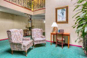 a hotel room with two chairs and a table at OYO Townhouse Tulsa Woodland Hills in Tulsa