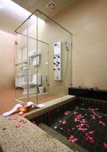 un baño con una bañera con flores rosas. en Flying Villa en Puli