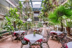 an indoor patio with tables and chairs and plants at OYO Townhouse Tulsa Woodland Hills in Tulsa