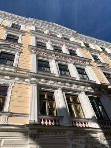een hoog wit gebouw met veel ramen bij Dandelion Apartment Vecpilsētas in Rīga