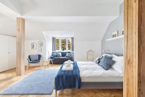 a bedroom with a large bed and a blue rug at Opera Apartments in Poznań