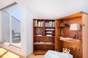 een kamer met een boekenplank en een bureau bij Lusitano Top Floor Apartment in Lissabon