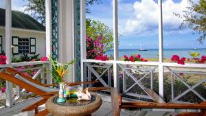 Oualie Beach Resort في نيفيس: كرسي على شرفة مطلة على المحيط