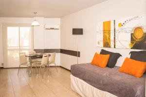 a bedroom with a bed with orange pillows and a table at Kube Apartments Express in Córdoba