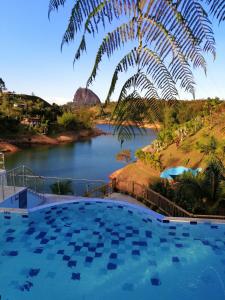 a large swimming pool next to a river at Hotel Santa Maria de las Aguas Peñol in Guatapé