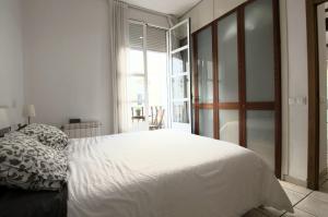 ein Schlafzimmer mit einem weißen Bett und einem Fenster in der Unterkunft Junto al Mercado de Ruzafa in Valencia