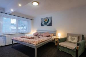 una camera da letto con un letto e una sedia di A&A Apartmany a Liptovský Mikuláš