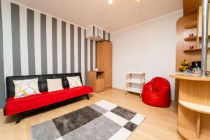 a living room with a red couch and a red chair at Apartament Kortowski in Olsztyn