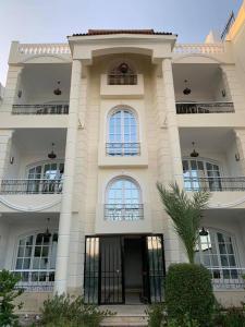 a large white building with windows and a door at White House Apartments in Luxor