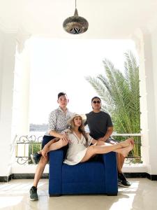 a group of three people sitting on a blue chair at White House Apartments in Luxor