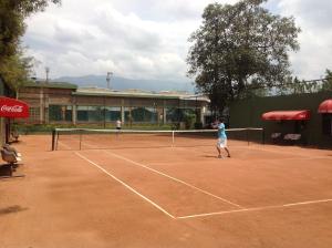 twee mensen die tennissen op een tennisbaan bij HH HACIENDA EL CARMEN CENTRO DE CONVENCIONES in Duitama