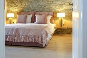 a bedroom with a large bed with two lamps at CAMARA SUITES in Andros