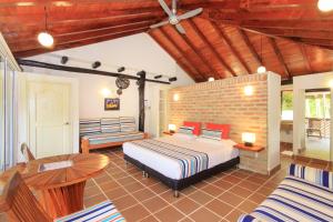 a hotel room with a bed and a table at La Mar de Bien in Buritaca