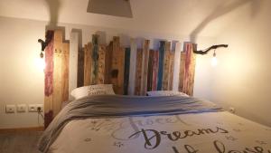 - une chambre avec un lit et une tête de lit en bois dans l'établissement LE PIC'ARDIE, à Pont-Sainte-Maxence