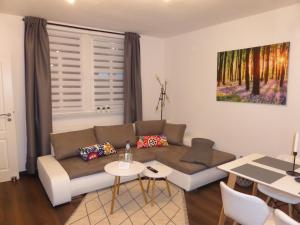 uma sala de estar com um sofá e uma mesa em Ferienwohnung Goethe, 2 Schlafzimmer, Nähe Zentrum & Uni, ruhig, free Wifi, kostenloses Parken, Erdgeschoss em Jena