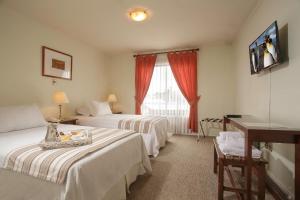 Hotel Carpa Manzano في بونتا أريناس: غرفة فندقية بسريرين ونافذة