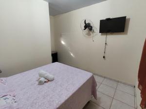 um quarto com uma cama e uma ventoinha na parede em Pousada do Professor em Pirenópolis