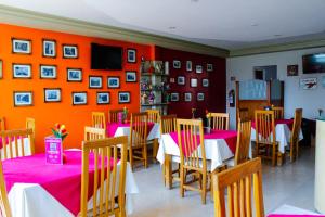 a dining room with red walls and tables and chairs at Plaza Fontesanta in Amecameca de Ju&aacute;rez