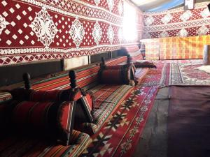 Habitación con moqueta y paredes estampadas en rojo y blanco en WadiRum Mobile Camp, en Wadi Rum