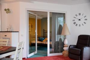 ein Wohnzimmer mit einer Uhr an der Wand in der Unterkunft Ferienwohnung Marosa in Willingen