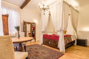 - une chambre avec un lit à baldaquin et une table dans l'établissement Palazzo DaPonte, à Venise