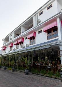 a building with a lot of windows and plants at Baratha Hotel & Resto in Bondowoso