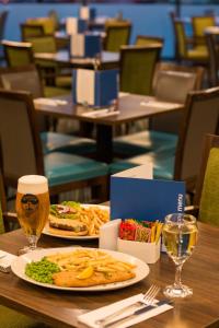 une table avec une assiette de nourriture et un verre de bière dans l'établissement Holiday Inn Express London Heathrow T5, an IHG Hotel, à Slough