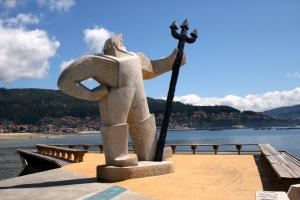 Eine Statue einer Frau, die eine Stange auf einem Pier hält. in der Unterkunft VISTAS O MAR in Moaña