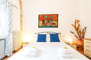 1 dormitorio con 1 cama blanca grande con almohadas azules en Rifugio Di Romeo e Giulietta, en Verona