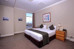 a bedroom with a large bed and a large window at Flinders Landing Apartments in Melbourne